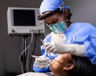 A dental professional working on a patient in a dental chair.