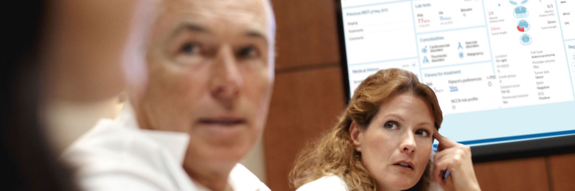 male and female medical professionals looking at screen