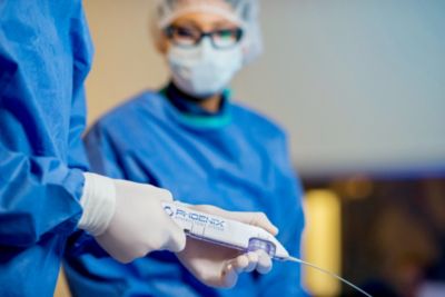 Clinician holding Phoenix Atherectomy device during procedure