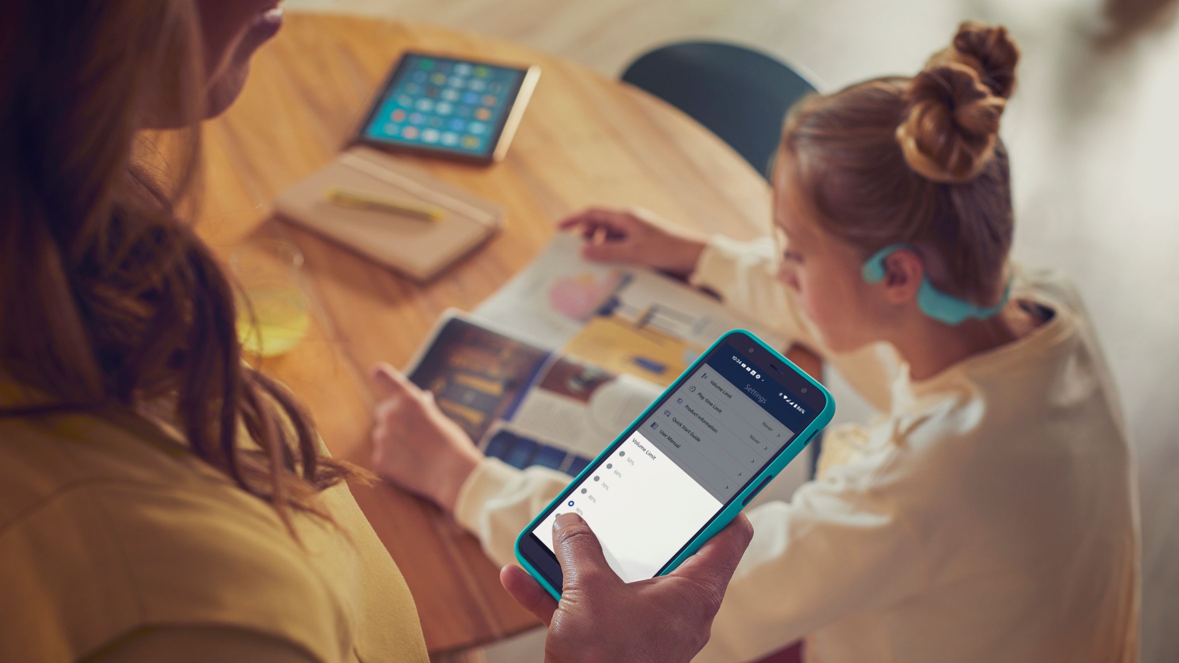 A parent using Philips Headphones app to control Kids Headphones volume