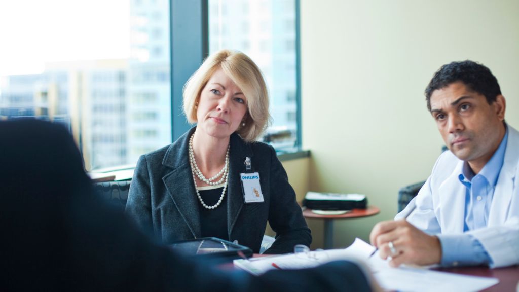 Clinician and hospital administrator discussing ownership or usage financing options
