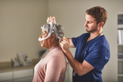 Clinician fitting patient with CPAP mask
