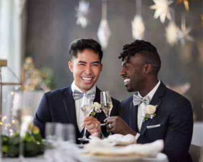 Two grooms smiling at a wedding.