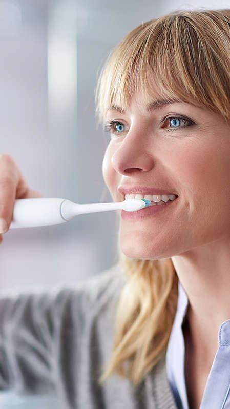 Woman using a Sonicare power toothbrush