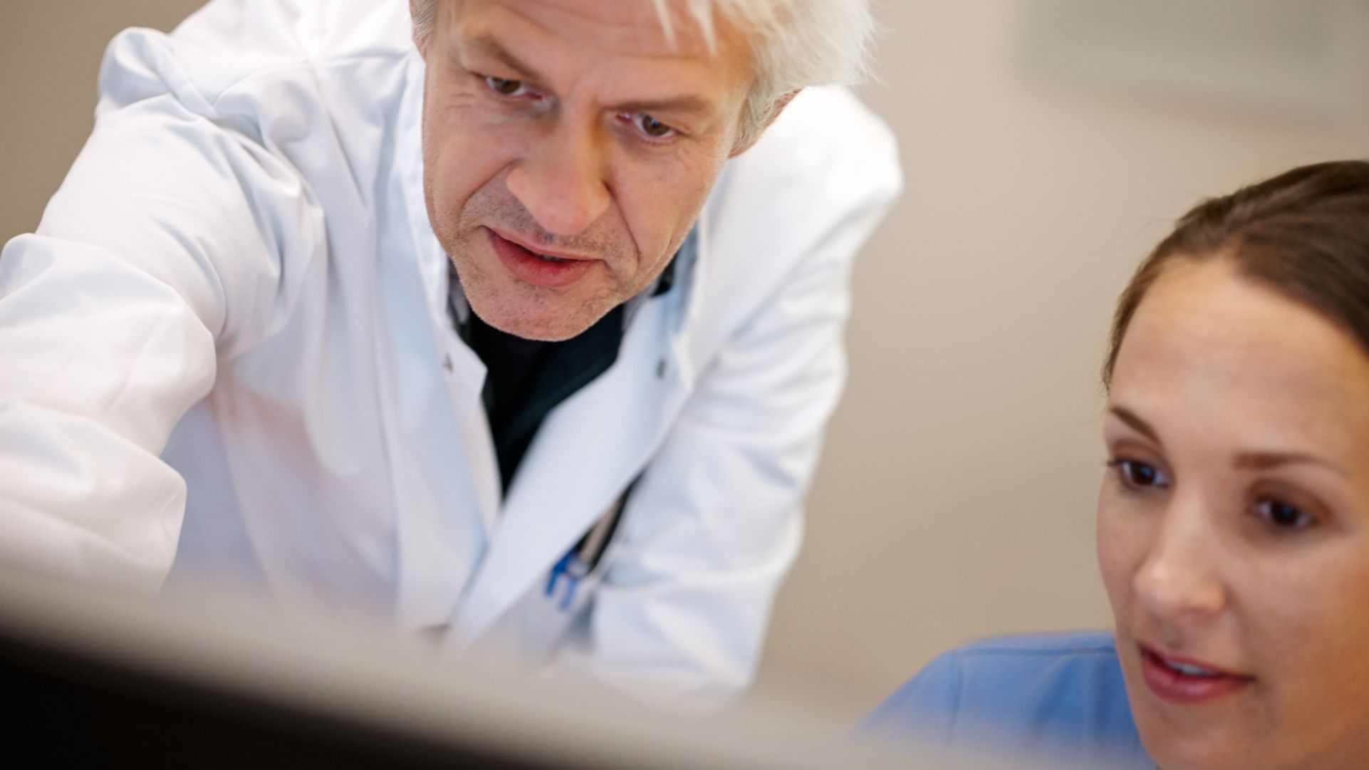 Radiologist and tech looking at screen in control room