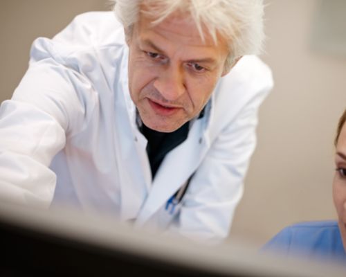 Radiologist and tech looking at screen in control room