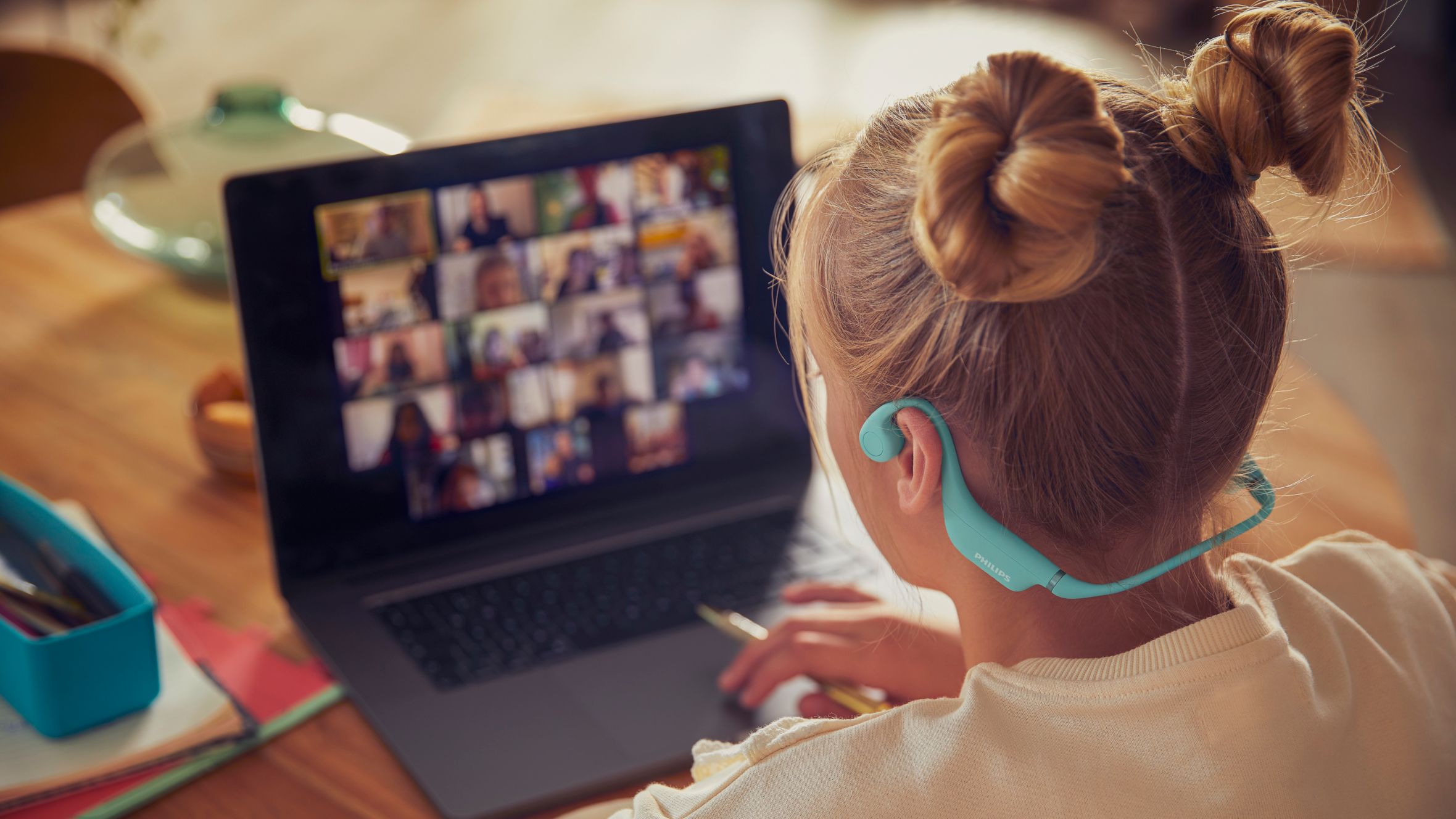 A girl using comfy kids headphones for a school activity