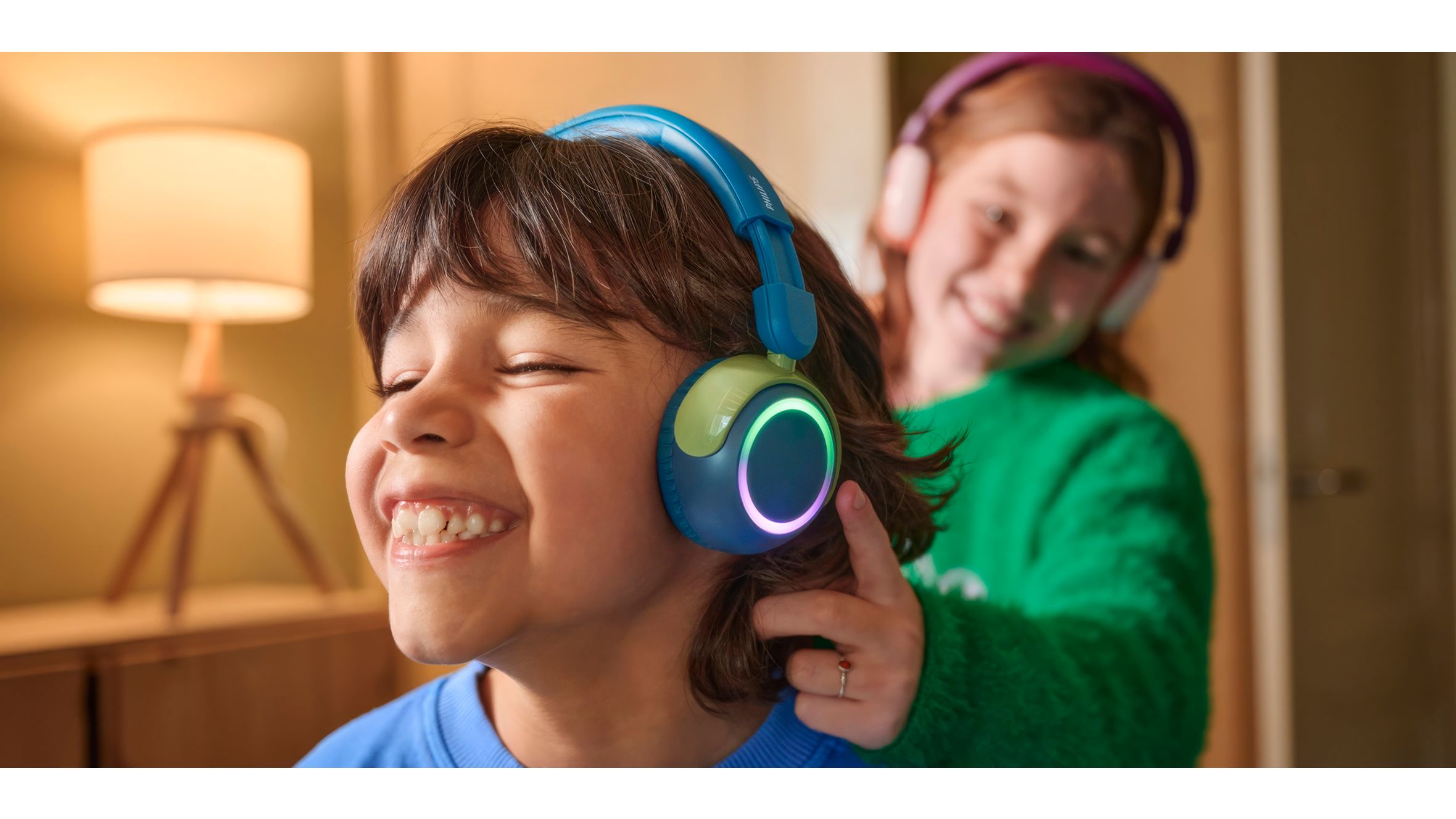 A boy and a girl using their devices while using durable kids headphones
