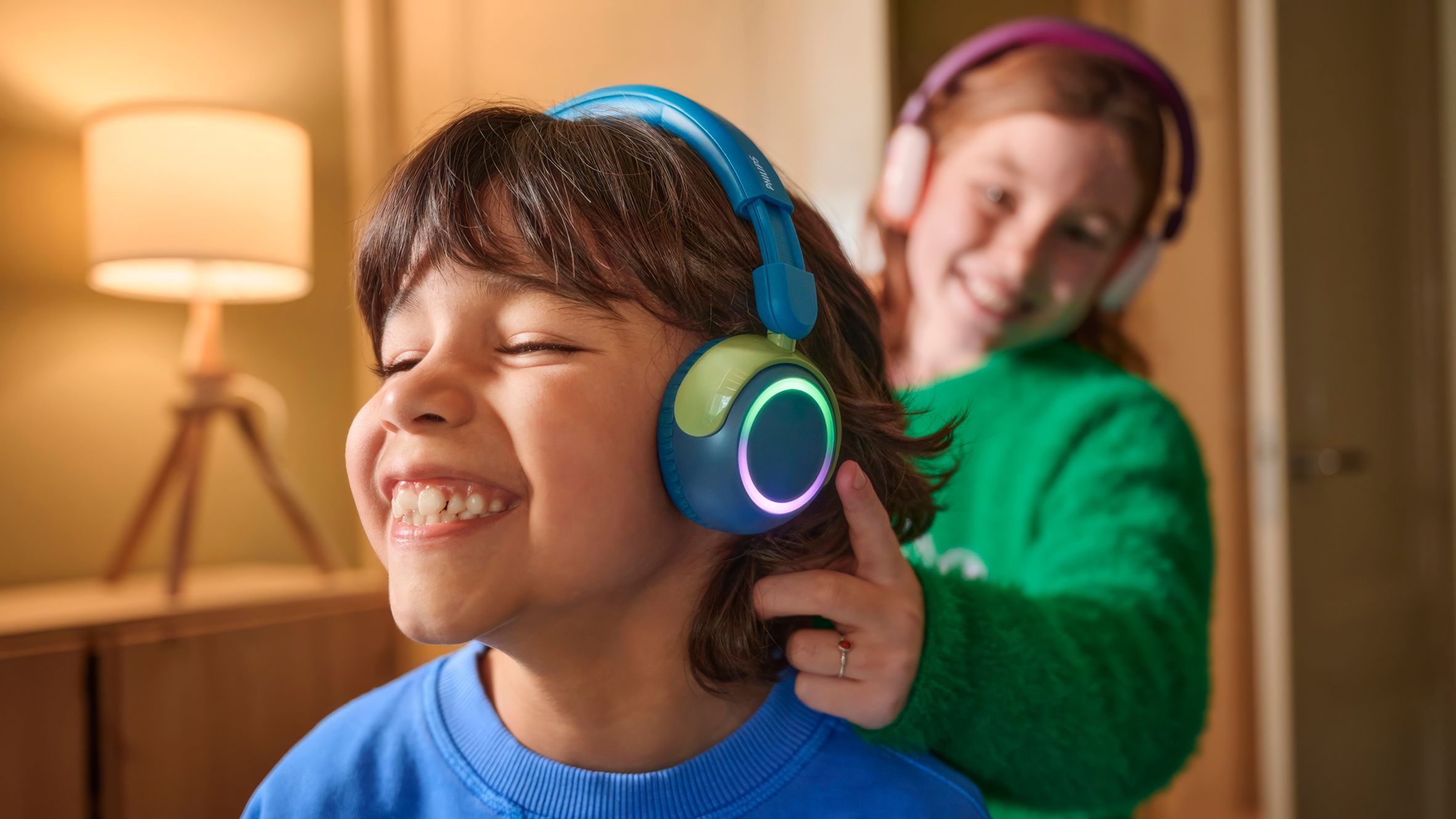 Egy fi&uacute; &eacute;s egy l&aacute;ny strapab&iacute;r&oacute; gyerek fejhallgat&oacute;val haszn&aacute;lj&aacute;k eszk&ouml;zeiket