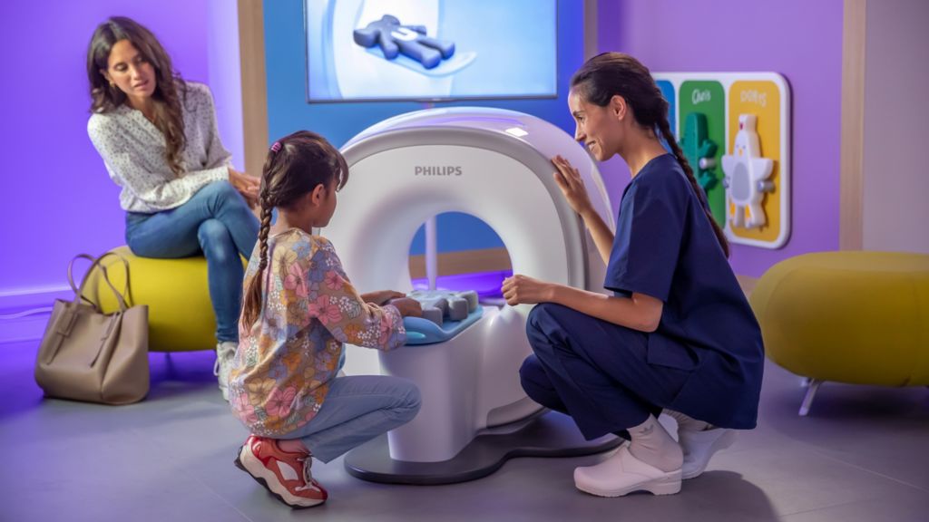 Mother, nurse and girl with Kitten Scanner sliding in Ollie the elephant.