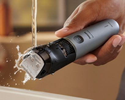 Man som sköljer trimmertillbehör i vatten