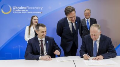 Afgevaardigden ondertekenen een overeenkomst tijdens de Ukraine Recovery Conference in Berlijn