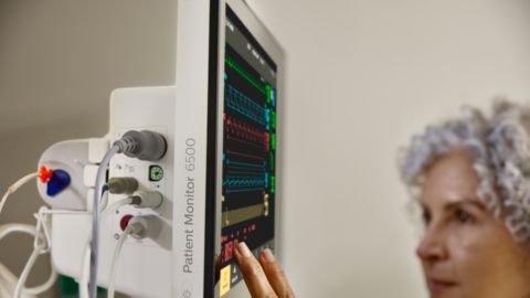 Médico conectando el cable al bastidor con el monitor del paciente