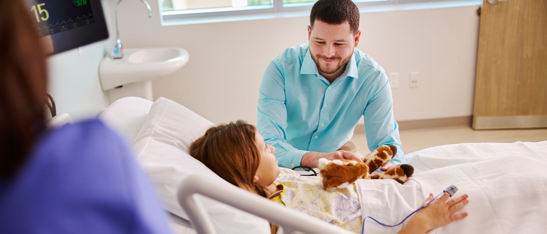 pediatric patient with teddy bear in hospital bed