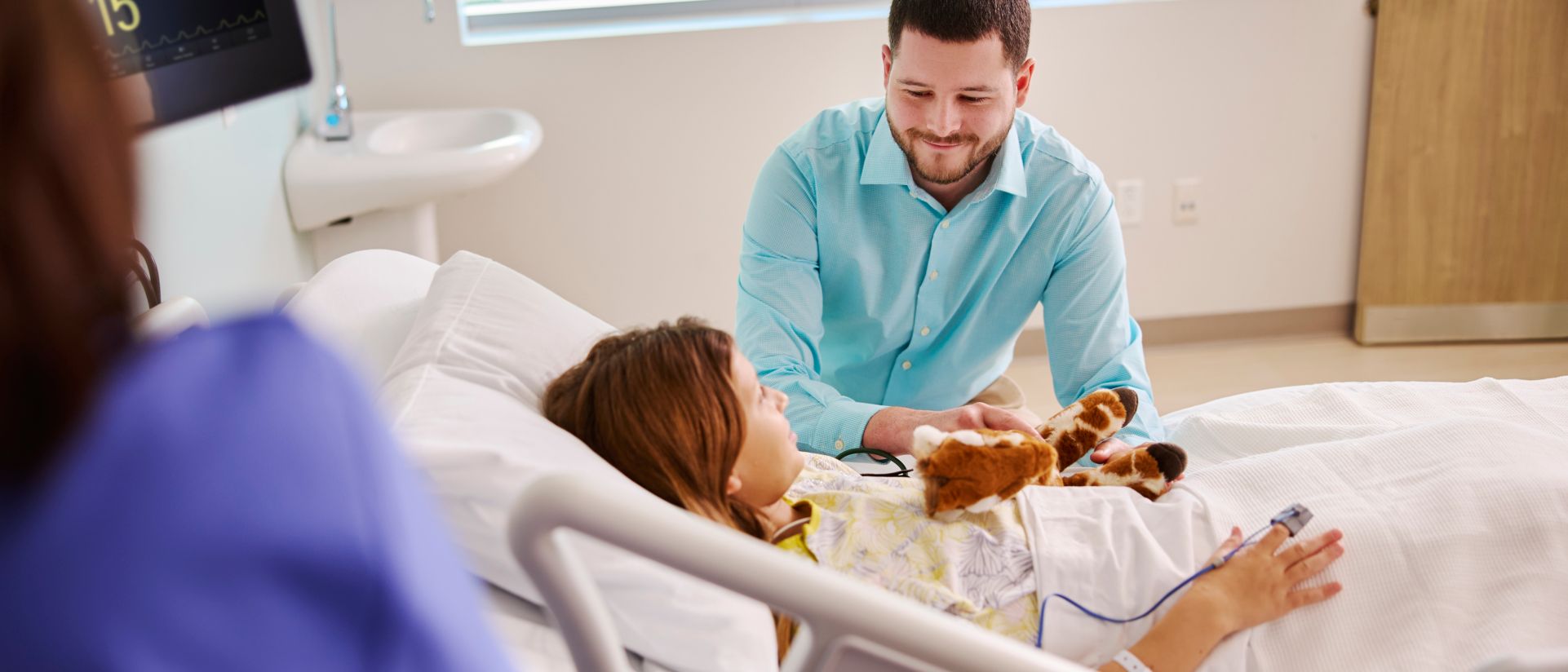 pediatric patient with teddy bear in hospital bed