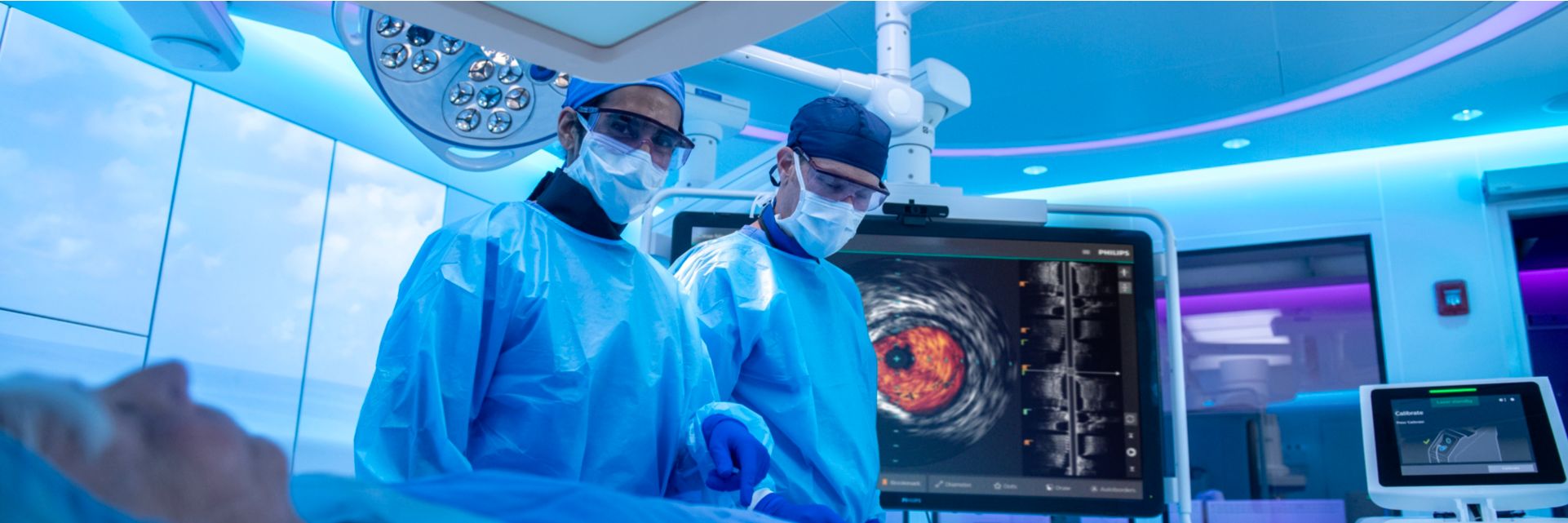 Physicians performing a peripheral procedure with Philips IVUS and laser system in the background