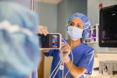 Nurse checking patient vital signs using Philips monitoring system in hospital