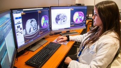 Profesional de la salud revisa imágenes de diagnóstico médico en varios monitores