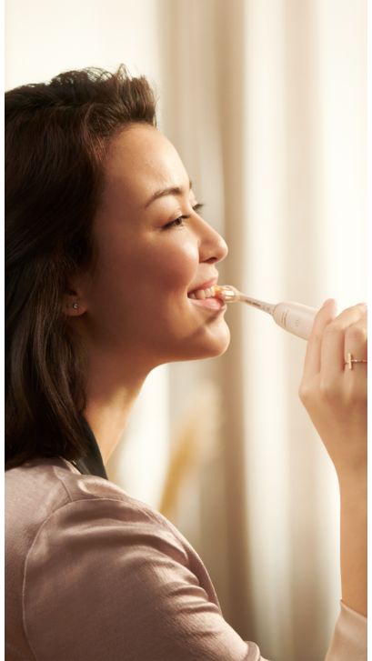 Mujer usando un Philips Sonicare 9900 Prestige