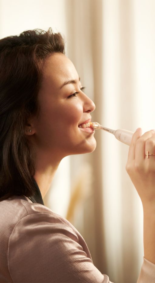 Woman using a Philips Sonicare 9900 Prestige