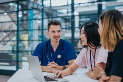 Clinicians reviewing information together on laptop in hospital setting