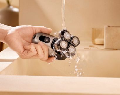 Philips waterproof head shaver being rinsed clean