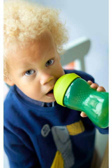 A kid drinking from a sippy cup