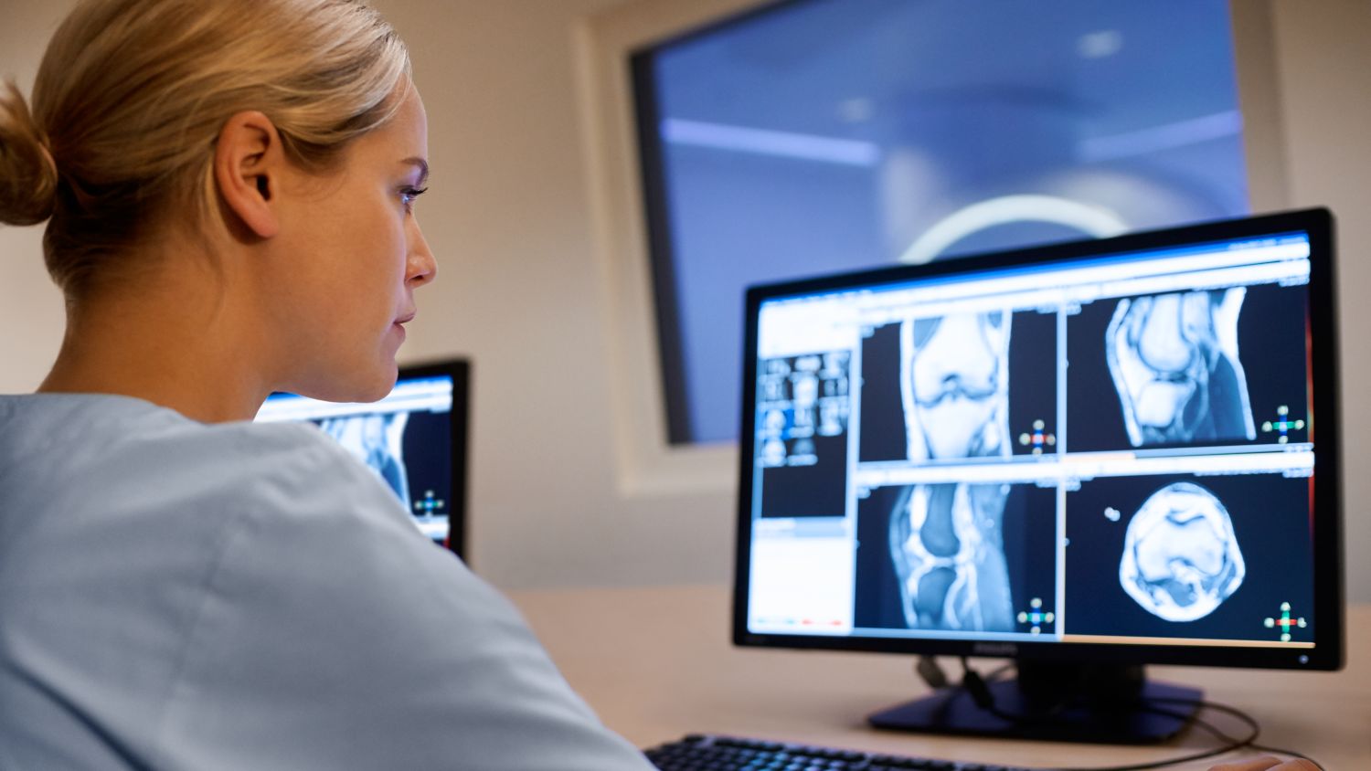 MR technologist sitting analyzing clinical images on screen