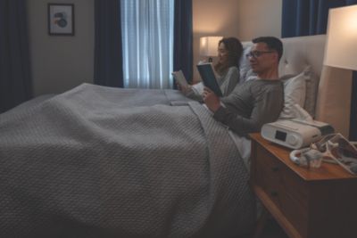 DreamStation on Nightstand with Wisp Mask, Couple reading in bed
