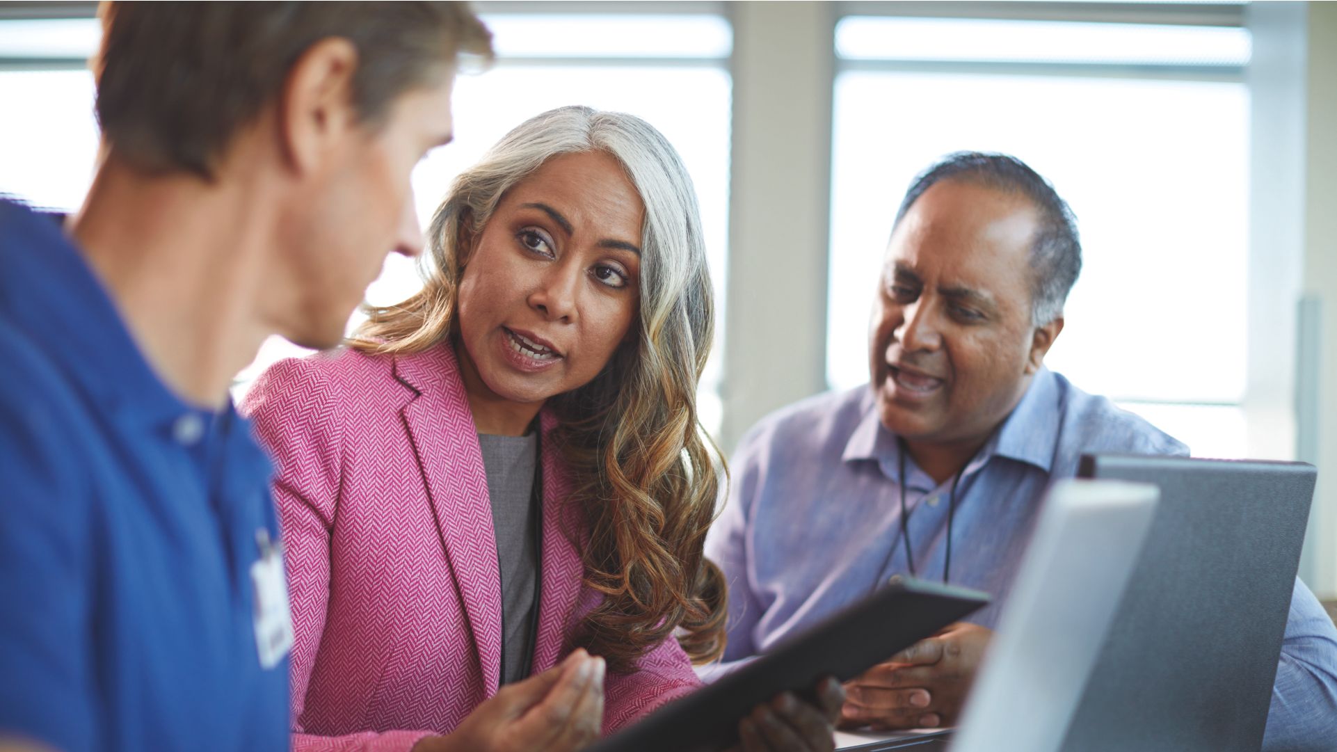 Healthcare professional meeting with others in front of monitor