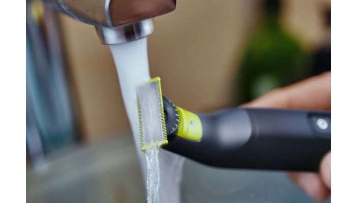 Photo en gros plan d´une lame Philips OneBlade lavée sous un robinet.