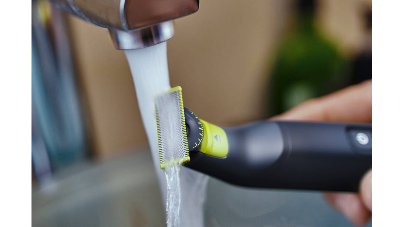 Eine Nahaufnahme eines Philips OneBlade, der unter einem Wasserhahn gewaschen wird.