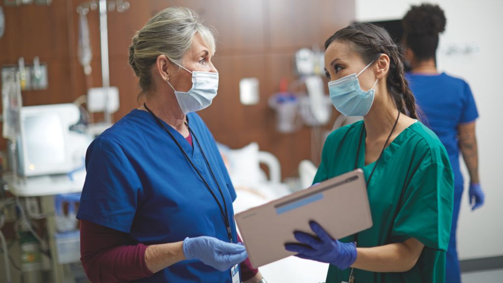 Clinicians in discussion using tablet