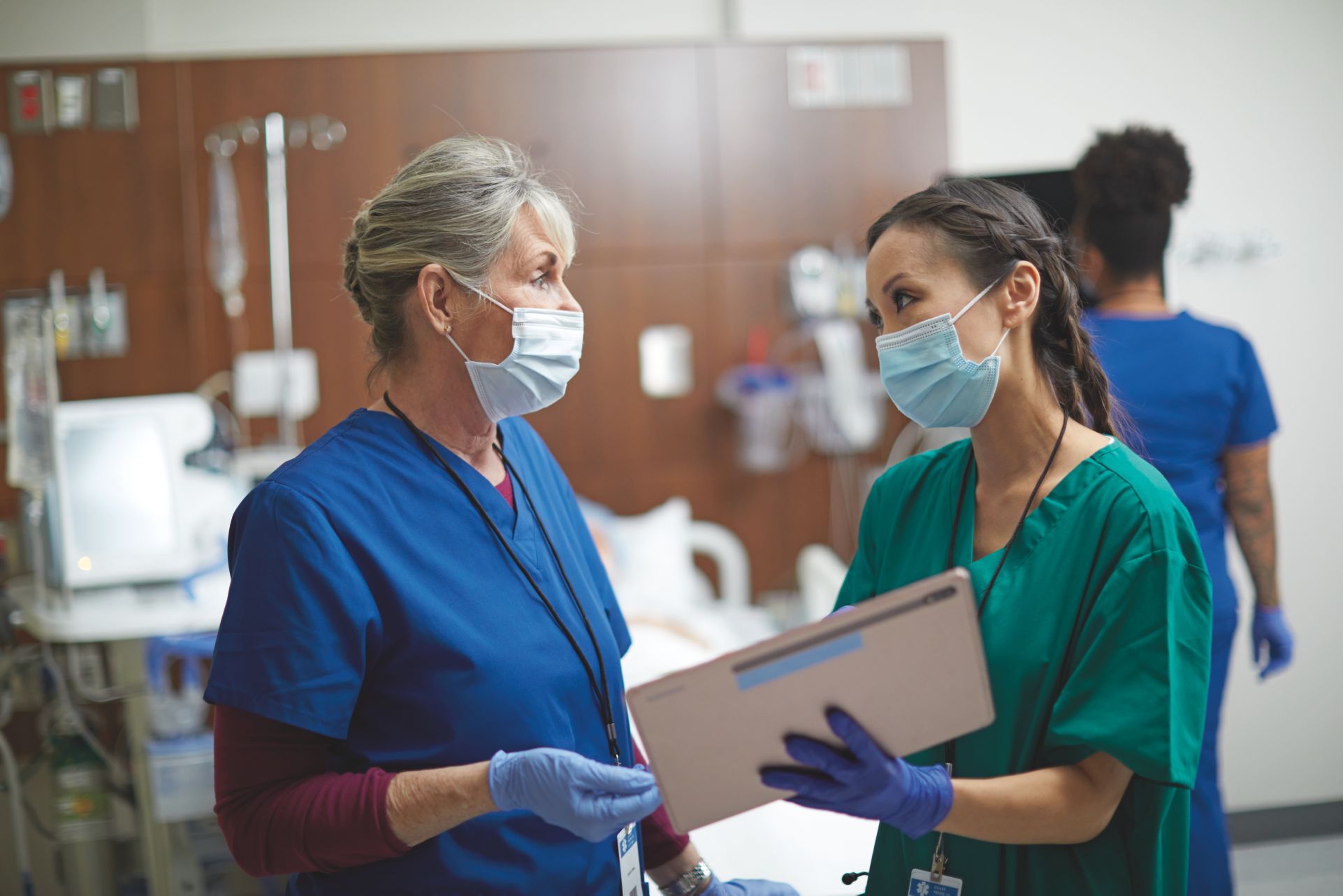 Two care providers consulting looking at a tablet
