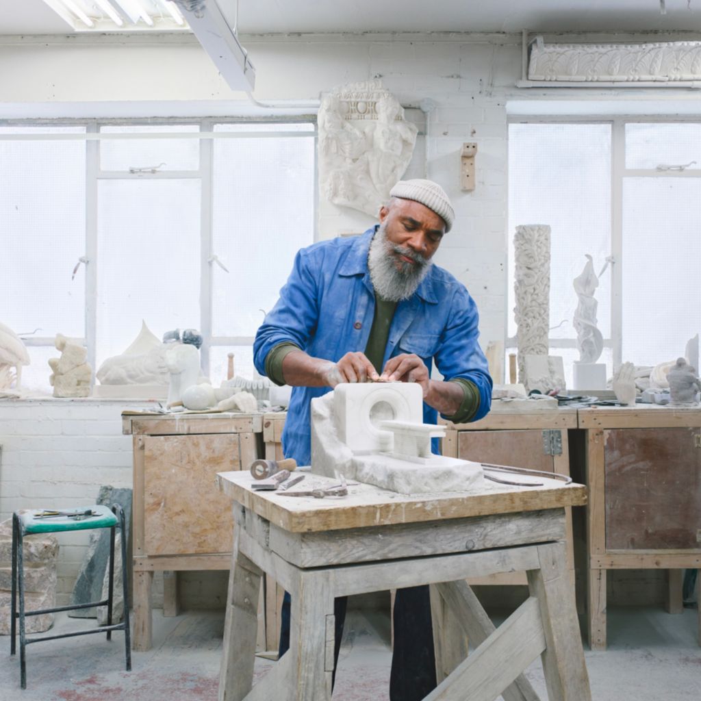 A man is sculpting in a studio