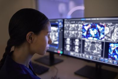 Clinician analyzing medical scans on dual monitors