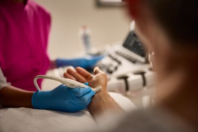 A healthcare professional operating a medical monitoring device in a clinical setting