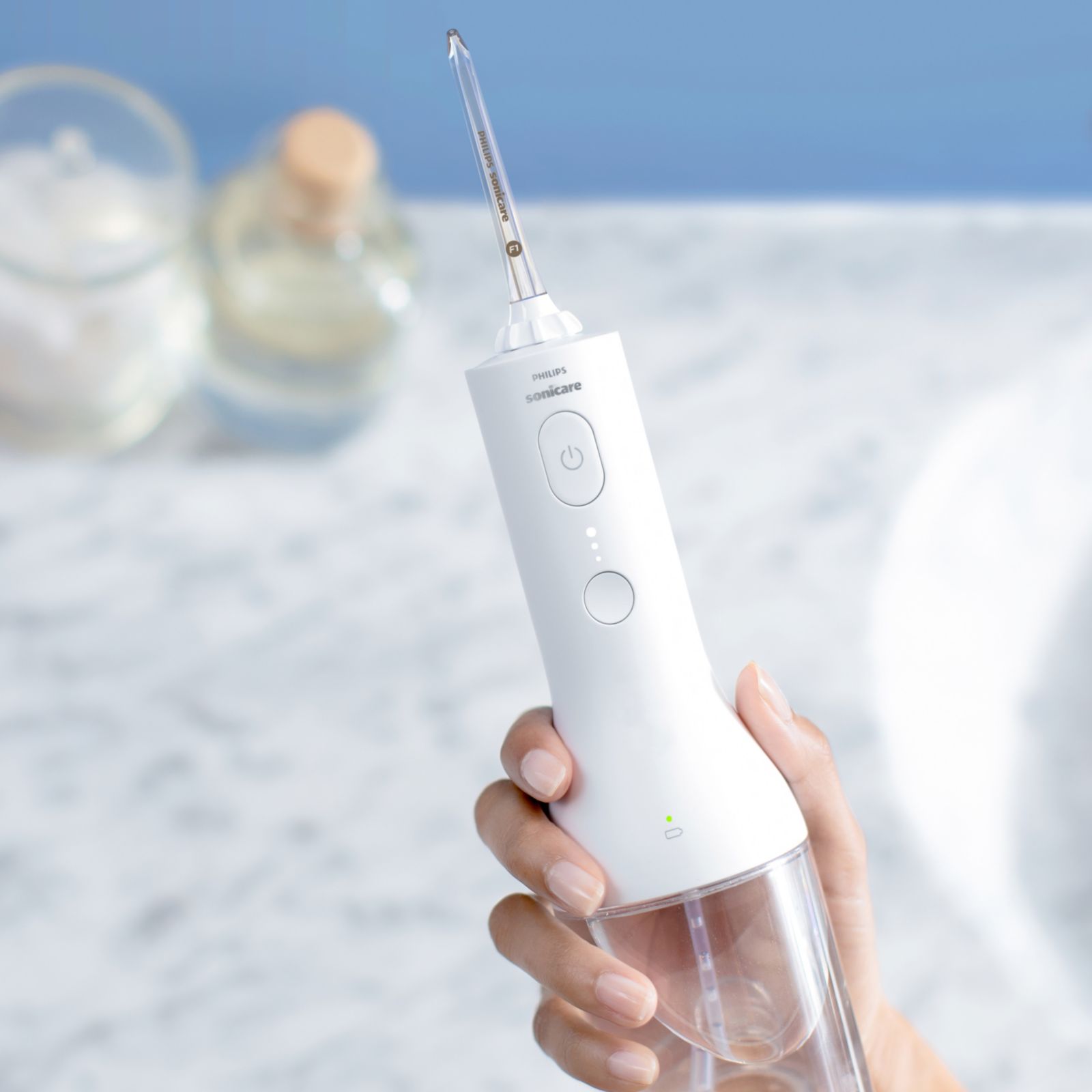 Hand reaching for a Power Flosser device on a countertop