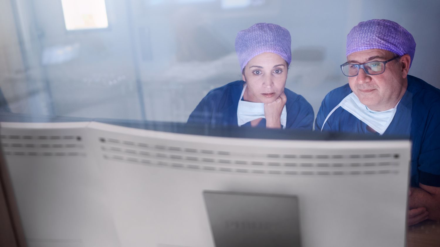 Clinicians viewing monitor at workstation