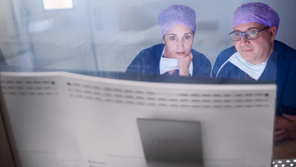 Clinicians viewing monitor at workstation
