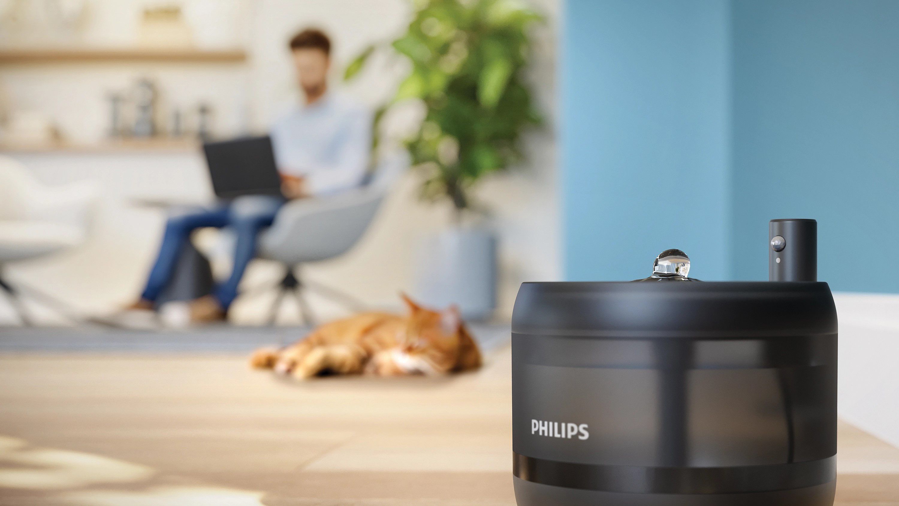 Lifestyle image of the Philips Pet Series Intelligent Pet Feeder with Camera 5000 Series PAW5320/02 positioned in a modern home interior, emphasizing discreet design and smart pet care integration