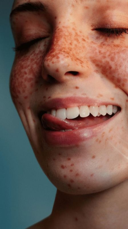 Een glimlachende vrouw laat haar tong over haar goed gepoetste tanden gaan