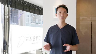 クリニック内装で口腔ケアのアドバイスを説明する歯科医