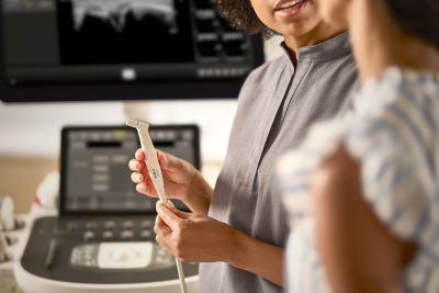 Clinician holding ultrasound transducer during aesthetic consultation