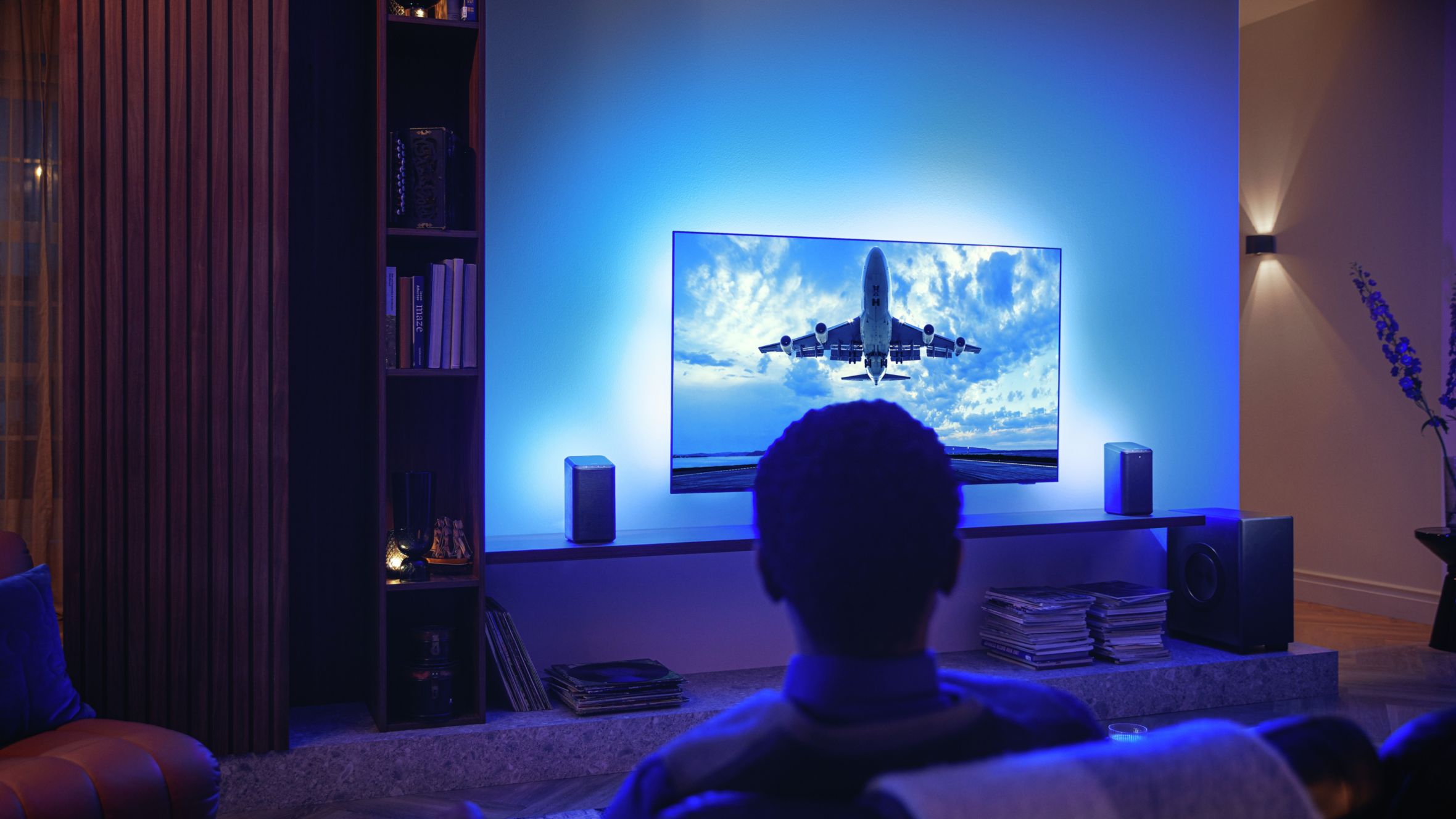 Mu&scaron;karac uživa u svom Philips Ambilight TV-u povezanom s Wi-Fi zvučnicima