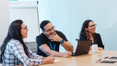 Three Philips employees smiling during office meeting