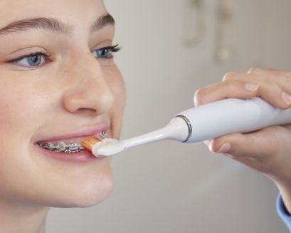 Patient with braces brushing front teeth