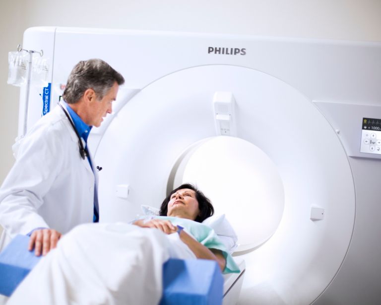 Clinician gives instructions to a patient on an IQon Spectral CT bed