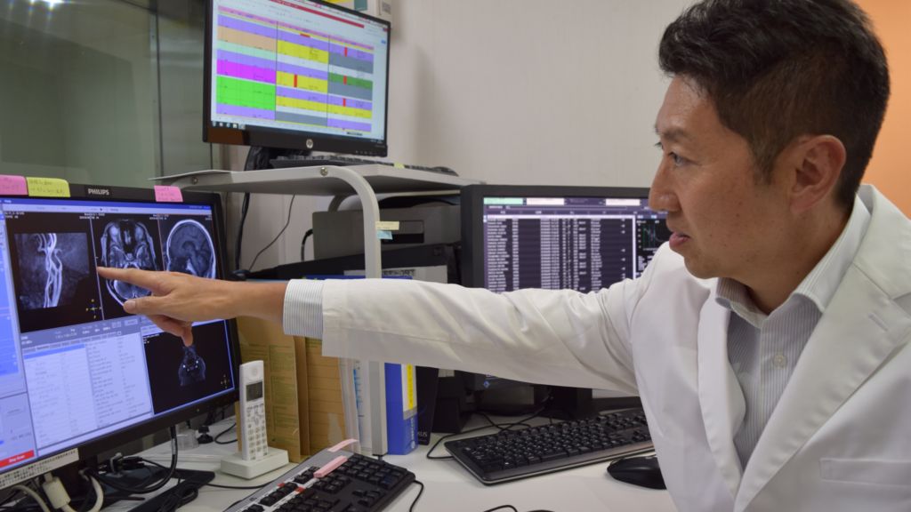 Hideki Koyasu investigating CT scan