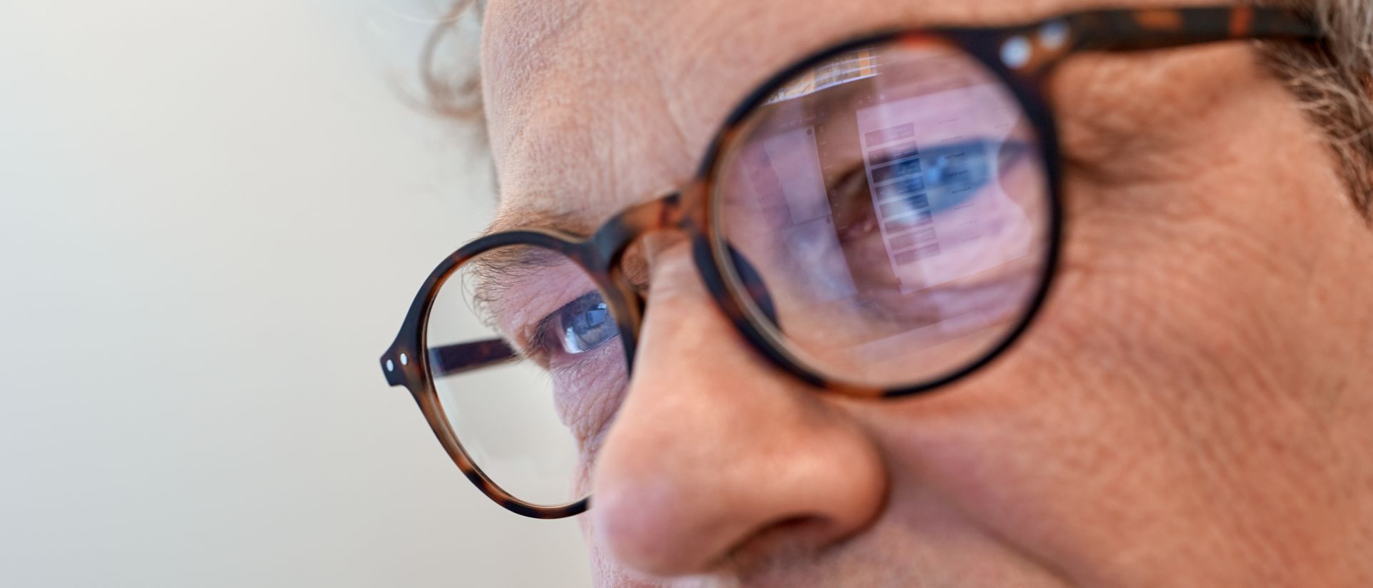 man with glasses looking at screen
